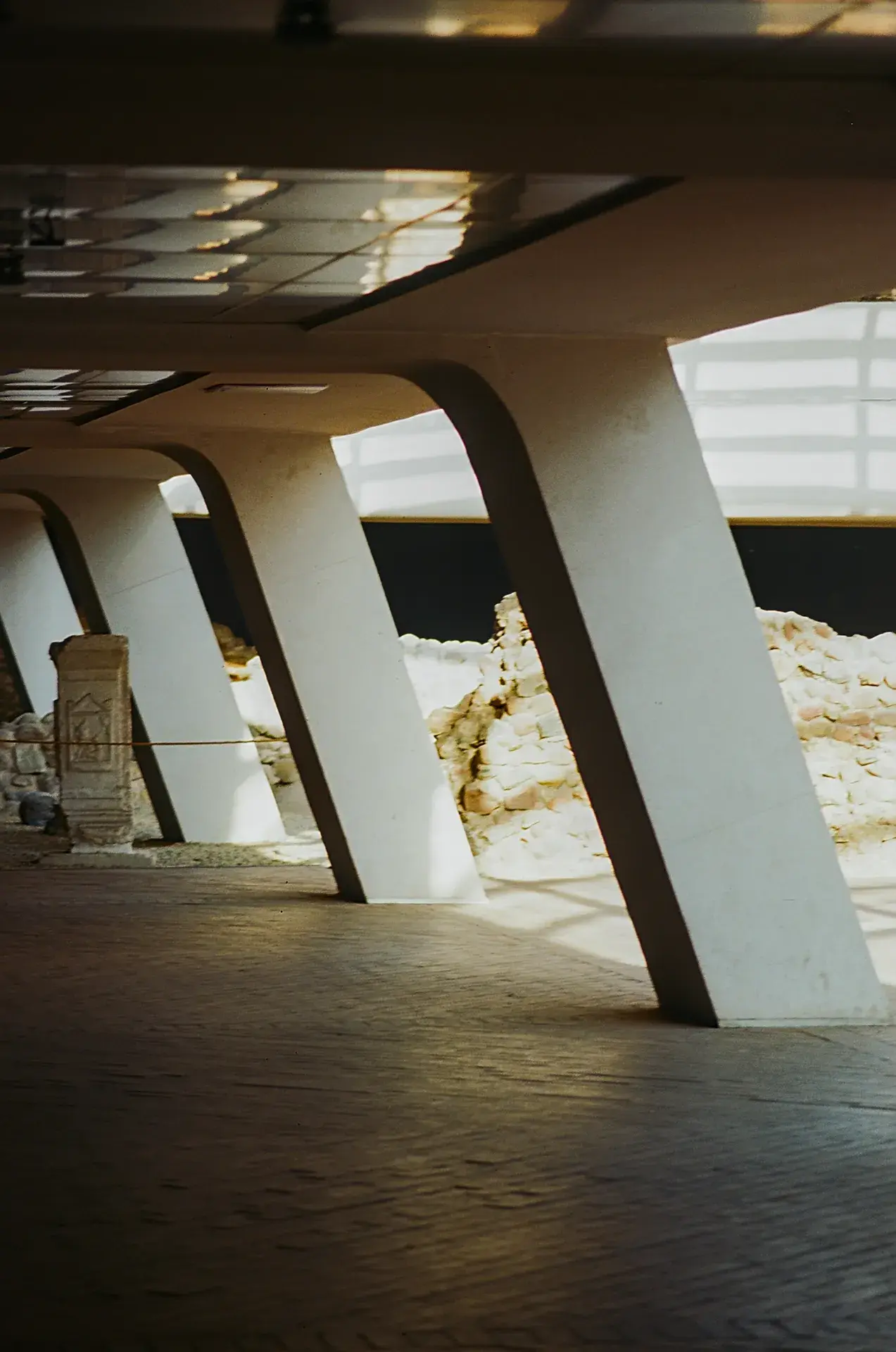 Two men conversing under an archway with a building in the background